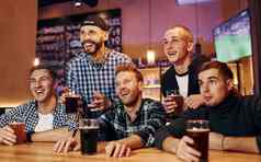 足球球迷看集团人在室内酒吧有趣的周末时间
