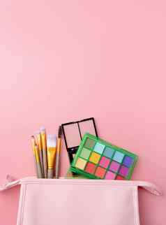 明亮的夏天眼影调色板化妆产品粉红色的化妆品袋粉红色的背景