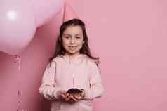 生日女孩粉红色的聚会，派对他站粉红色的氦气球持有蛋糕微笑相机