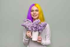 少年女孩染色紫色的黄色的头发持有淡紫色花手