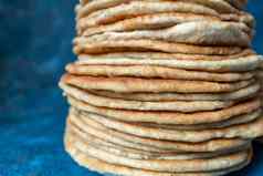 面包亚美尼亚式面包查帕蒂馕饼堆玉米粉圆饼蓝色的背景自制的面包堆放