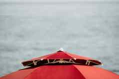 红色的海滩伞背景蓝色的海海洋海滩景观夏天旅行假期概念