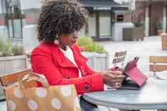 非洲美国快乐年轻的女人眼镜阅读电子书购物在线