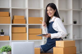 肖像年轻的亚洲女人电子商务员工坐着办公室完整的包背景写请注意订单计算器锻造业务电子商务交付业务