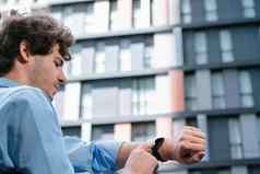 年轻的进步商人触屏智能手表检查时间