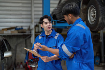 机械师男人。显示报告亚洲同事车库男人。机械师儿子讨论维修车辆改变汽车业务