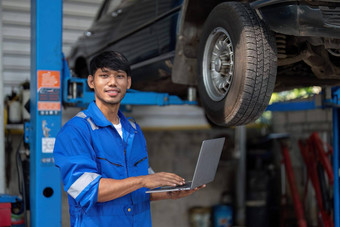 肖像积极的亚洲汽车机械师统一的摆姿势工作敏锐的修复汽车汽车