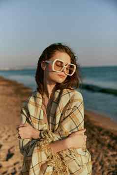 肖像女人巨大的眼镜包装格子享受温暖的一天海面对相机
