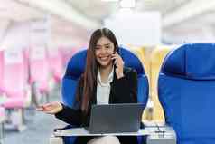 美丽的亚洲业务女人聊天客户端移动电话飞行工作旅行业务概念
