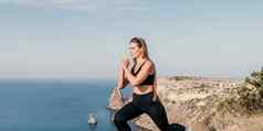 健身女人海户外锻炼瑜伽席公园海洋海滩女健身普拉提瑜伽例程概念健康的生活方式快乐适合女人锻炼橡胶乐队公园
