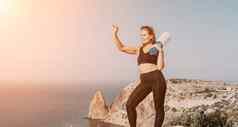 健身女人海户外锻炼健身橡胶乐队公园海滩女健身普拉提瑜伽例程概念健康的生活方式快乐适合女人锻炼橡胶乐队公园