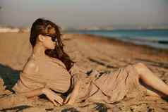 红发女人黑暗太阳镜谎言海滩阳光明媚的一天风吹头发