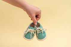 一对小鞋子新生儿婴儿女手黄色的背景新生儿概念