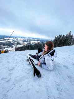 拍摄滑雪女人坐着滑雪坡休息放松极端的娱乐活跃的生活方式活动女滑雪坡山冬天活跃的体育运动