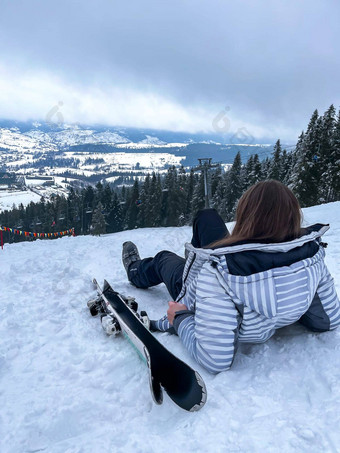 拍摄滑雪女人坐着滑<strong>雪坡</strong>休息放松极端的娱乐活跃的生活方式活动女滑<strong>雪坡</strong>山冬天活跃的体育运动