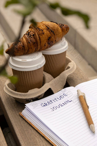 写作感激之情杂志木板凳上咖啡羊角面包早....例程今天感激的发现杂志反射有创意的写作增长个人发展概念幸福精神上的健康考虑到整体健康实践