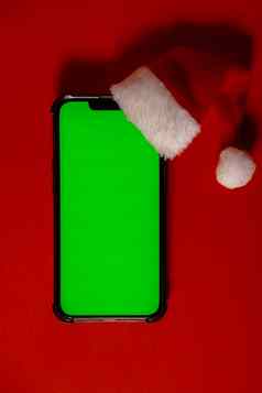 移动电话穿着圣诞老人的红白他浓度关键屏幕红色的背景概念圣诞节年假期空白细胞电话数字小工具无线愿望列表概念社会媒体广告