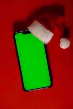 移动电话穿着圣诞老人的红白他浓度关键屏幕红色的背景概念圣诞节年假期空白细胞电话数字小工具无线愿望列表概念社会媒体广告