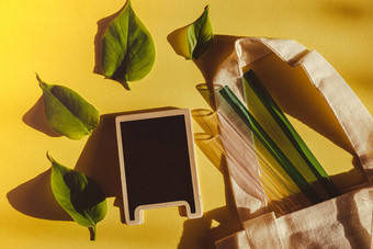 可重用的玻璃吸管色彩斑斓的背景绿色树叶生态袋环保空黑板上模拟模板复制空间文本喝稻草集可重用的舒适的圆形的提示喝稻草浪费塑料免费的概念野餐概念