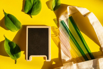 可重用的玻璃吸管色彩斑斓的背景绿色树叶生态袋环保空黑板上模拟模板复制空间文本喝稻草集可重用的舒适的圆形的提示喝稻草浪费塑料免费的概念野餐概念