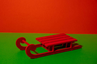 红色的雪橇简约概念等角风格红色的绿色颜色复制空间文本装饰红色的雪橇模型时尚的产品站显示展示产品货物冬天圣诞节明信片问候卡