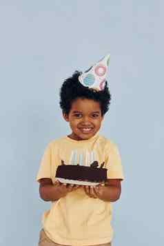 快乐非洲美国孩子有趣的在室内生日聚会，派对持有蛋糕