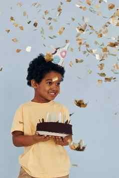 快乐非洲美国孩子有趣的在室内生日聚会，派对持有蛋糕