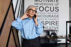 肖像成功的中间岁的老业务女人执行移动电话办公室概念成功的业务发展