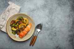 美味的大马哈鱼角烤布鲁塞尔豆芽板乡村混凝土背景前视图健康的晚餐烤鱼蔬菜平衡营养空间文本