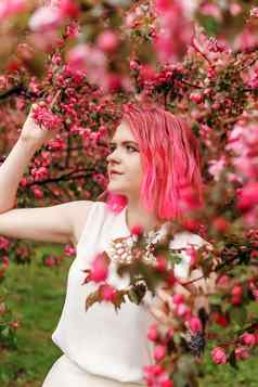 年轻的女孩粉红色的头发苹果果园