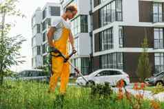 现代建筑男人。减少草草坪上动机在户外院子里
