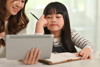 无聊学生女孩家庭作业妈妈。首页在家教育教育概念