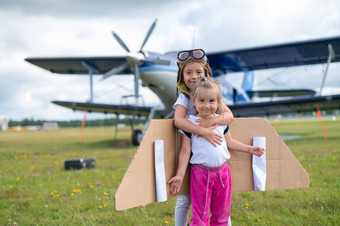 女孩飞行员的服装拥抱场飞机螺旋桨姐妹梦想飞行天空