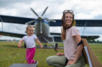 高加索人女人女儿玩飞行员背景小飞机螺旋桨