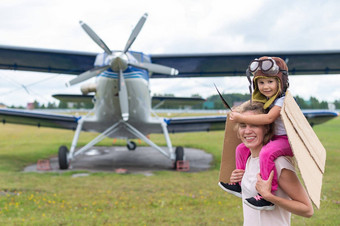 高加索人女人女儿玩飞行员背景小飞机螺旋桨