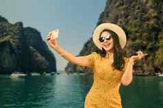 快乐的女人夏天衣服使移动电话海背景人假期生活方式旅程概念