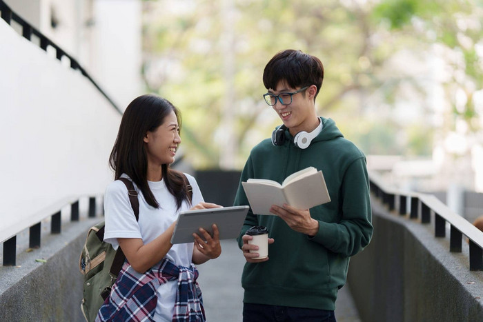 年轻的亚洲女人大学学生朋友在户外大学学生