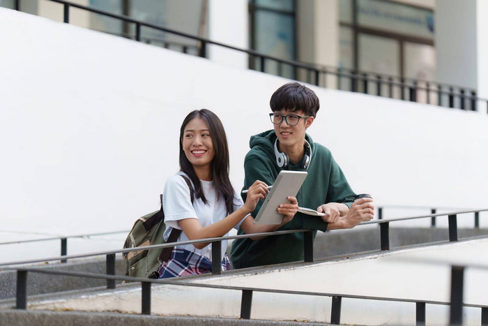 年轻的亚洲女人大学学生朋友在户外大学学生