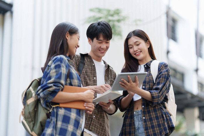 年轻的亚洲女人大学学生朋友在户外大学学生