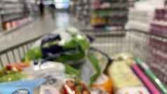 电车超市视图购物车焦点认不出来人选择产品超市架子上购买食物生活必需品未来