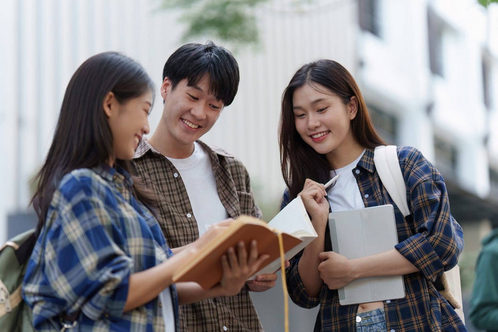 年轻的亚洲女人大学学生朋友在户外大学学生