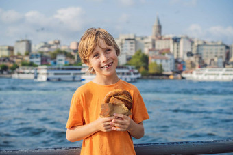 男孩伊斯坦布尔早餐simit玻璃土耳其茶玻璃土耳其茶百吉饼simit金角湾加拉塔塔伊斯坦布尔<strong>火鸡</strong>突厥语旅行孩子们概念