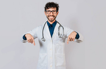 年轻的医生指出促销活动英俊的医生指出孤立的广告空间快乐医生指出手指