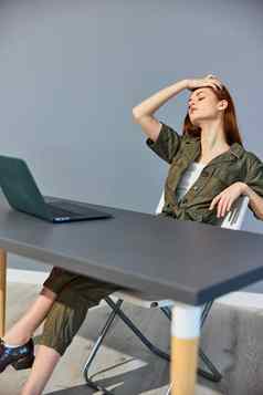 累了女人坐在工作移动PC办公室整理了一下头发手
