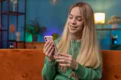 高加索人年轻的女人坐着沙发智能手机分享消息社会媒体应用程序