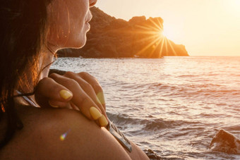 女人海瑜伽快乐女人冥想瑜伽构成日落海滩海洋岩石山动机鼓舞人心的适合锻炼健康的生活方式在户外自然健身概念