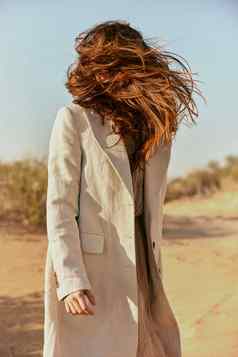 强大的风膨胀女人红色的长头发