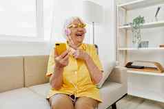 快乐上了年纪的女人电话视频调用微笑技术沟通明亮的现代室内生活方式在线沟通