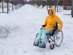 高加索人女人残疾的人游乐设施椅子公园冬天女孩走轮椅