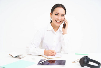 业务公司概念年轻的亚洲女人经理工作办公室写作信息会说话的客户<strong>端移动</strong>电话白色背景